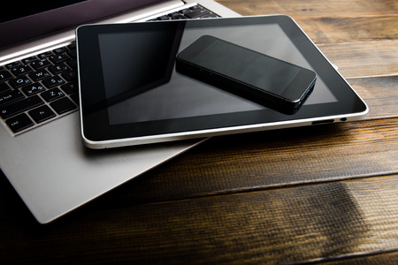 keyboard with phone and tablet pc on wooden deskの写真素材