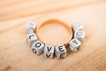 Message "I love you" spelled in metallic blocks and golden ringの写真素材