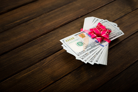 new 100 US dollars banknotes (bills) on wooden backgroundの写真素材