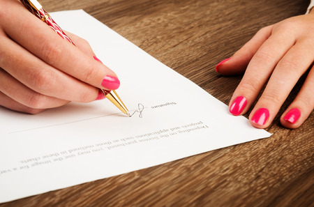 businesswomans hand with pen signing a contract