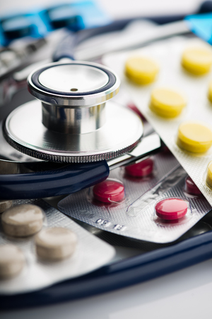 stethoscope and different colored pills in blistersの写真素材