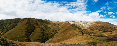 Panorama of Caucasian mountains near Gergeti Trinity Church, village of Gergeti and Stepancminda in Georgia.の写真素材