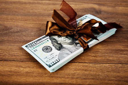 Stack of money with a bow around it