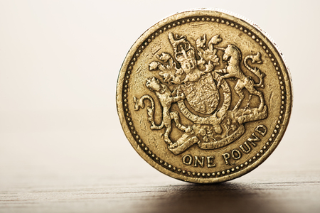 pound GBP coin and gold money on the desk の写真素材