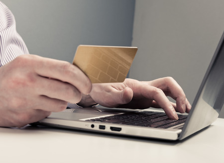 Businessman hand holding credit card and use laptopの写真素材