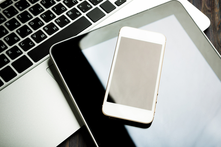 keyboard with phone and tablet pc on wooden deskの写真素材
