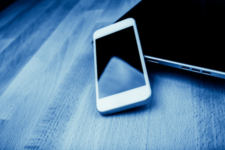 keyboard with phone and tablet pc on wooden desk, blueの写真素材