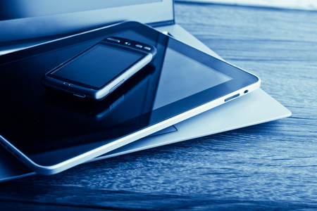 keyboard with phone and tablet pc on wooden deskの写真素材