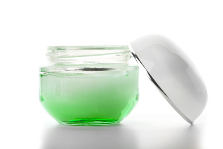 green glass jar of beauty cream with cap, isolatedの写真素材