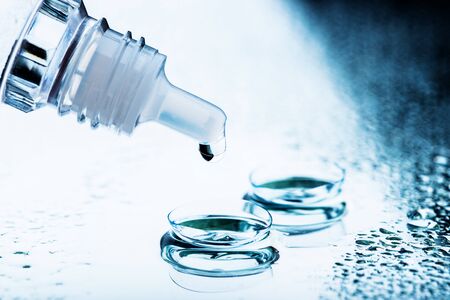 Bottle with lens solution and case on tableの写真素材