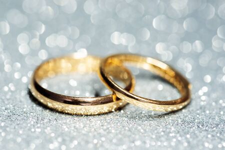 Gold wedding rings. Glitter backgroundの写真素材