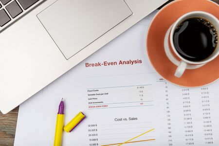 Office workplace table with report pages and coffee cupの写真素材