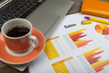 Office workplace table with report pages and coffee cup