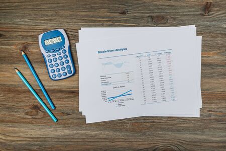 Office workplace table with report pages, coffee cup and calculator