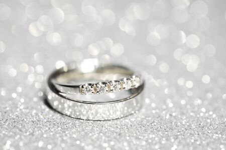 pair of platinum wedding rings. Glitter background