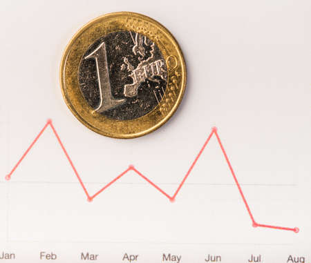 One euro coin on fluctuating graph. Rate of euro (shallow DOF)の写真素材
