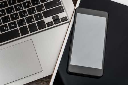 laptop with phone and tablet pc on wooden desk