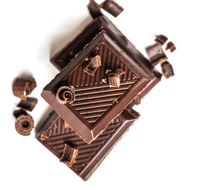 Curls and pieces of tasty chocolate on white table