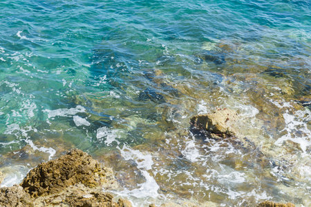 beach with rocks in blue waterの写真素材