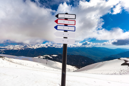 Modern sign with notations at the top of a snow-capped mountain in the spring at height of 2320 meters with a blue sky with light clouds. Ski Resort at Caucasus Mountains, Rosa Peak, Sochi, Russia.の写真素材