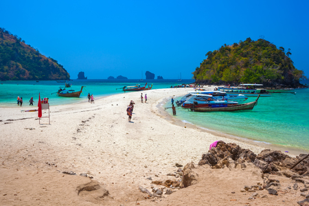 Tropical island at high tide. Vacationers walk on the sand at sea. Tup Island, AO Nang, Krabi, Thailand - Februrary 2014.の写真素材
