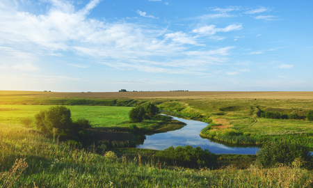 Sunny summer landscape with fields, river bend and beautiful woods.の写真素材