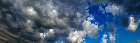 Background of dark stormy clouds in blue sky