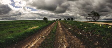 Ground country road passing through the farm fields.