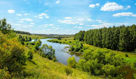Sunny summer landscape with green hills, river and beautiful woods in nice day.