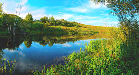 Beautiful summer landscape with calm river at sunset.の写真素材