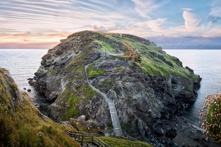 Peninsula of Tintagel Island and legendary castle ruins at sunsetの写真素材