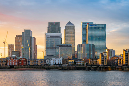London, United Kingdom - December 22, 2016: View across river Thames to skyscrapers district Canary Wharf in London at sunset. Copy space in sky.のeditorial素材