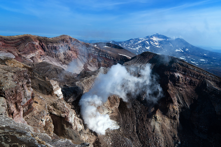 a view from the top edge of the volcanic crater of the volcano Gorely, and the neighboring volcano Mutnovskyの写真素材