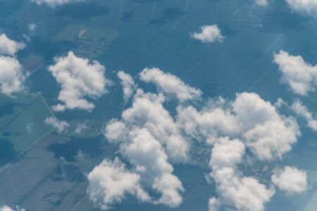 View from an airplane on the ground, clouds field and blue sky. Cloud wallpaper