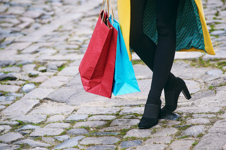 Closeup of a young woman carrying bags while walking down the streetの写真素材