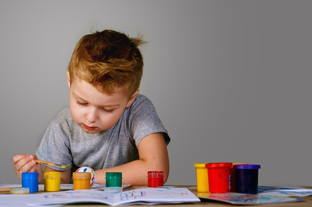 Boy with hands painted in colorful paintsの写真素材