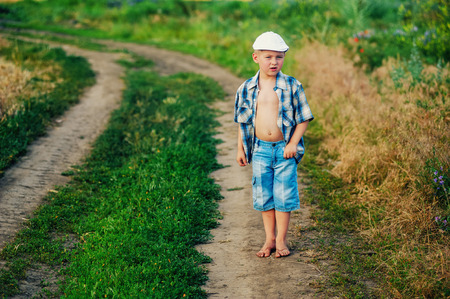 Stylish little boy in a rural locationの写真素材
