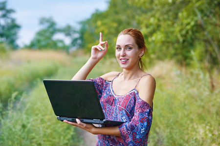 a young emotional girl with laptop in the Parkの写真素材