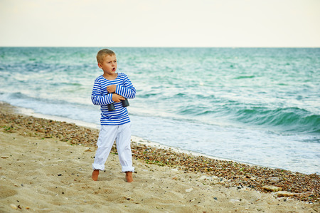 Boy posing on the beach dressed in a marine styleの写真素材