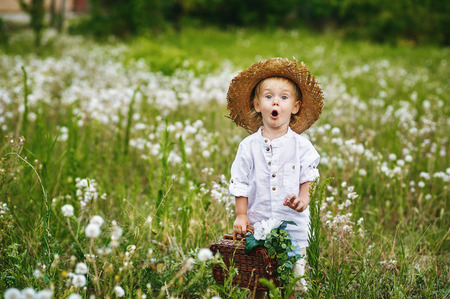 Little boy in field with dandelions, dressed in retro clothesの写真素材