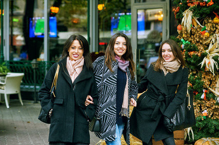 Three young cute girls having fun together on a city walk. A way of life.の写真素材