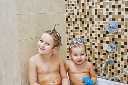 Cheerful children playing in the bathroom .Brother and sister enjoying water proceduresの写真素材