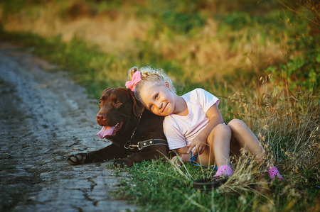 girl walking with a dog breed Labradorの写真素材