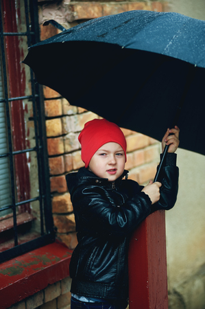 the boy holding the umbrella , the Spring walking in the rainの写真素材