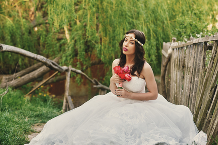 Young beautiful bride in the flowered garden . Wedding dayの写真素材