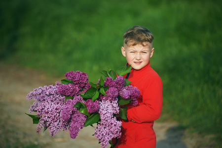 portrait of a boy with a bouquet of lilacの写真素材