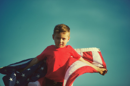 Happy boy with the American flag. Patriotic holiday. Flag of the USA