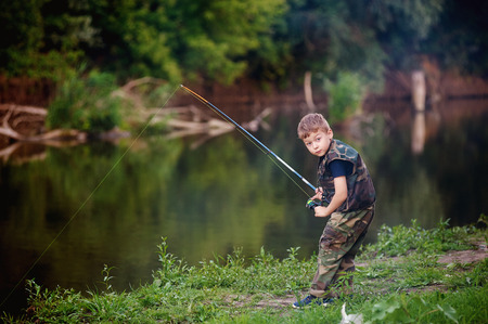 Boy catches fish in the river.The concept of tourism and leisureの写真素材