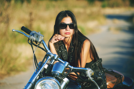 Sexy biker woman sitting on his motorcycle in the city. Beauty, fashion. Of adventure and freedom.の写真素材