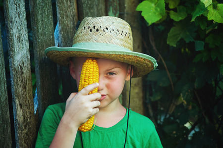 boy holding corn in his hands .Natural healthy foodの写真素材